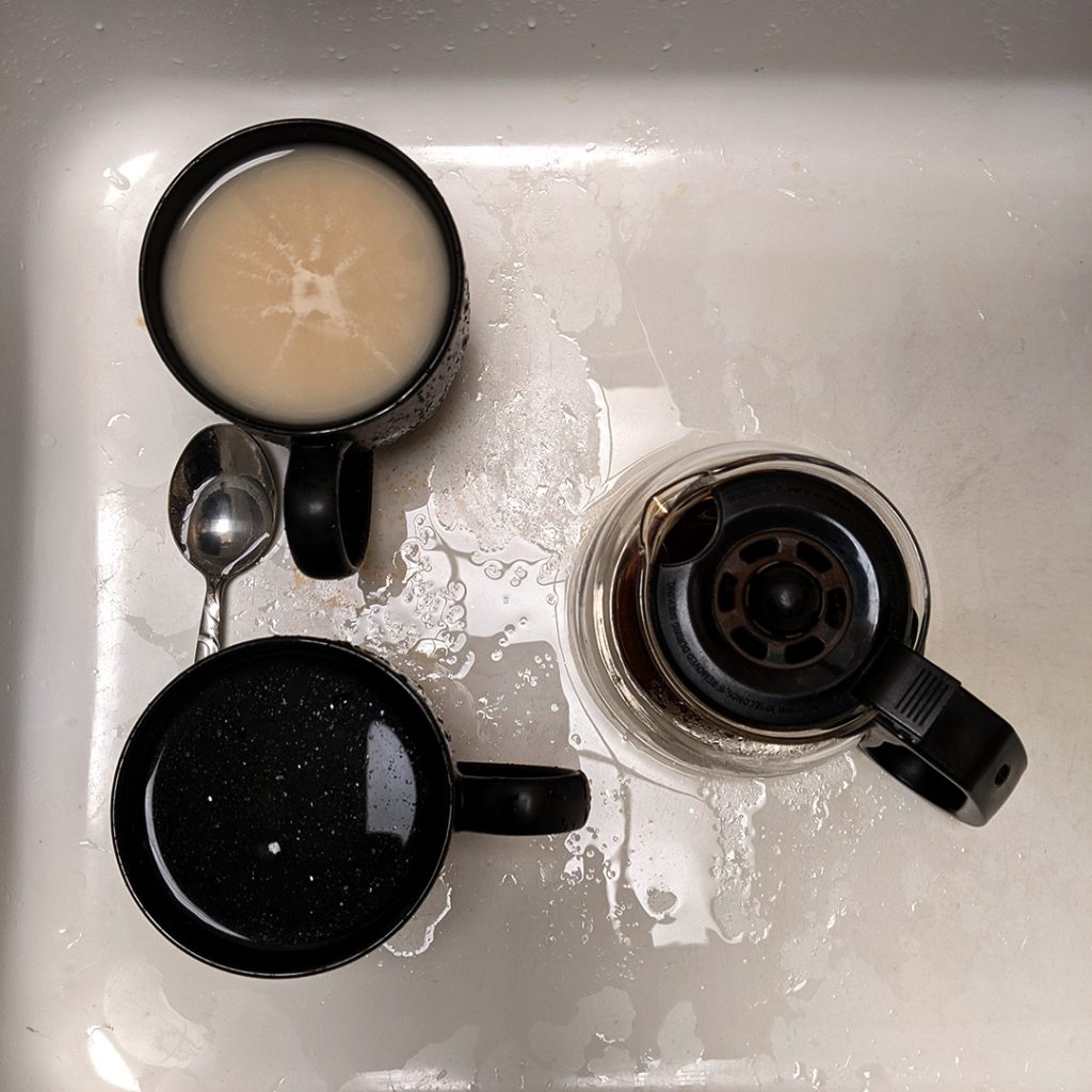 image of coffee mugs and coffee pot in a kitchen sink viewed from above
