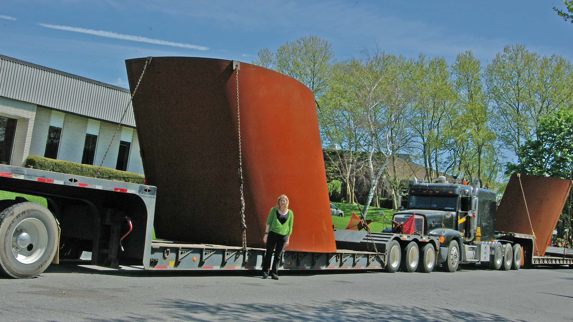 image of Richard Serra's curved sculpture on flatbed trucks