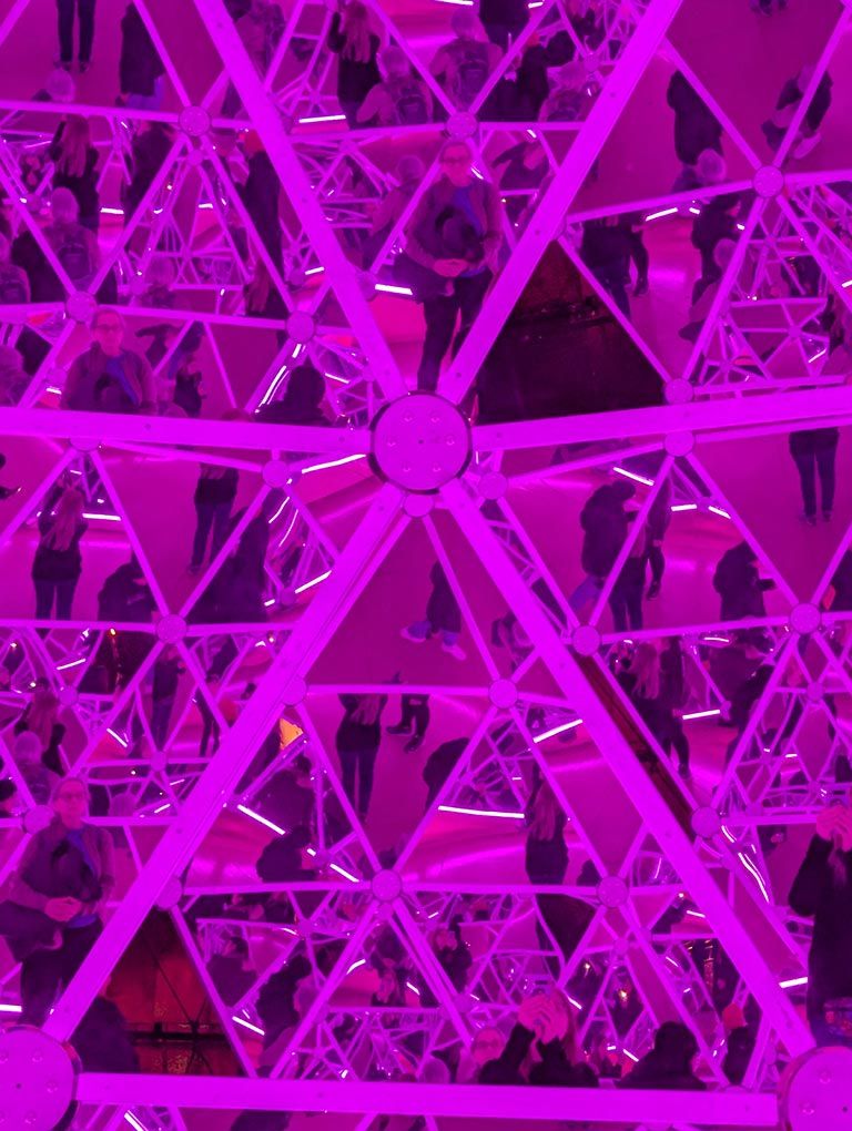 image of the inside of a mirrored dome with magenta lighting