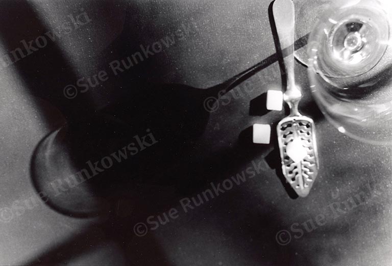 image of a glass of absinthe and slotted spoon with sugar cubes